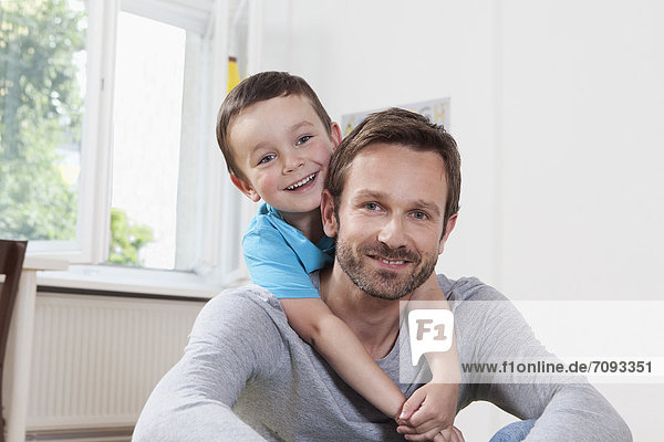 Germany  Berlin  Father and son at home  smiling  portrait