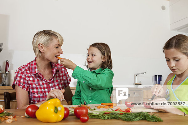 Germany  Bavaria  Nuremberg  Mother and children cutting vegetables