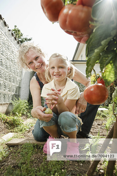 Germany  Bavaria  Grandmother and granddaughter working in vegetable garden