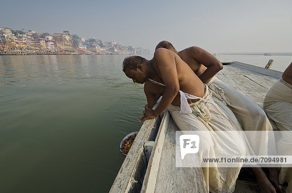 Die Überreste eines eingeäscherten Familienmitglieds werden dem heiligen Fluss Ganges geopfert  Varanasi  Indien  Asien