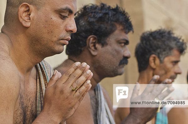 Praying men performing a ritual for the soul of a deceased person  at the ghats of Varanasi  India  Asia