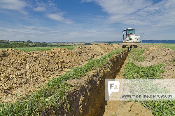 Bagger gräbt einen Graben durch ein landwirtschaftliches Gebiet  Laurich  Sachsen  Deutschland  Europa