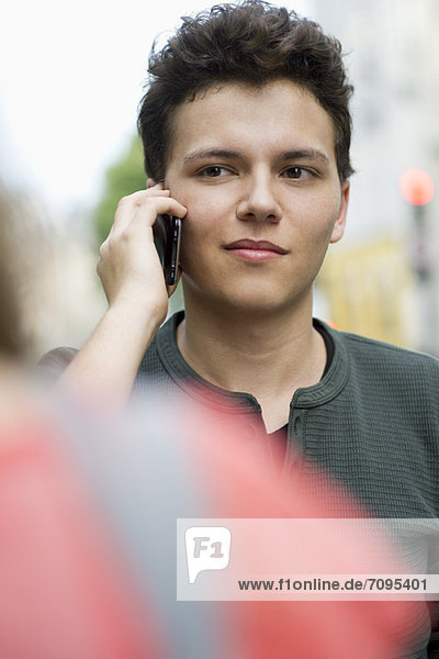 Young man using cell phone outdoors