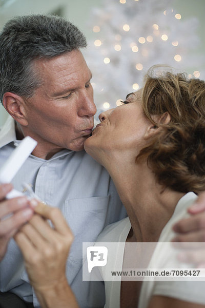 Mature couple kissing  man giving woman gift