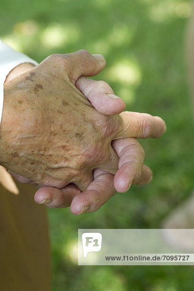 Ältere Menschen haben die Hände umklammert.