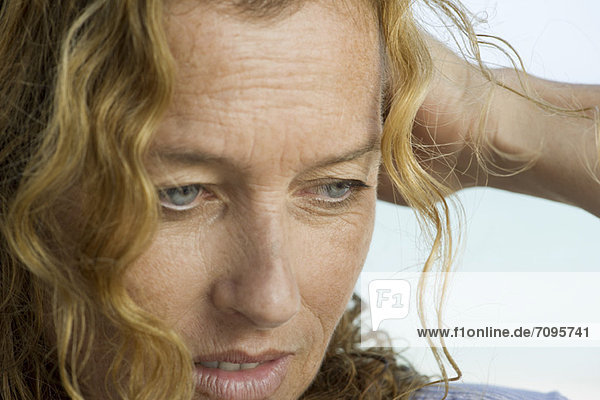 Mature woman looking down in thought