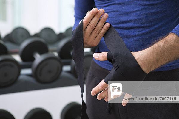 Boxer wrapping his hands in gym
