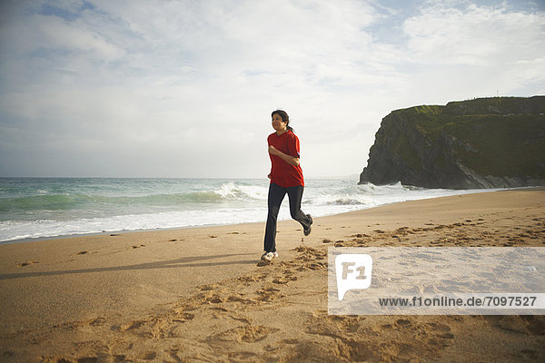 Frau läuft am Strand