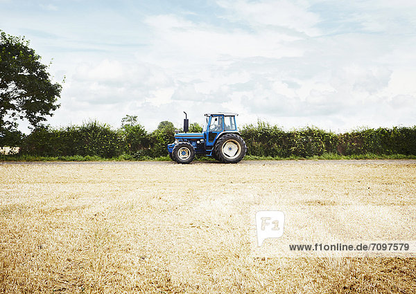 Tractor driving in tilled crop field