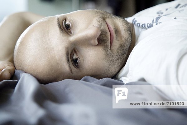 Man with designer stubbles lying in bed  portrait