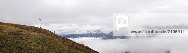 Berglandschaft mit Gipfelkreuz im Nebel  Südtirol  Italien