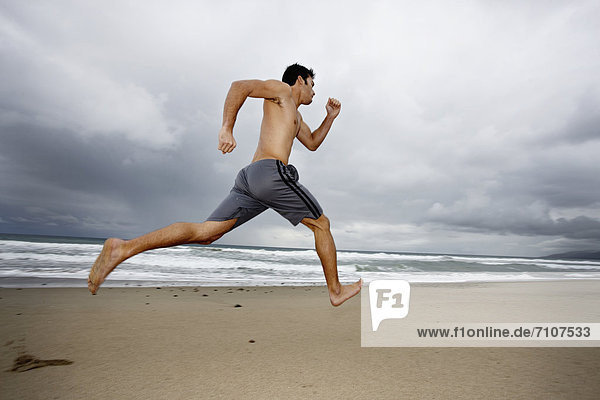 Young man running on beach