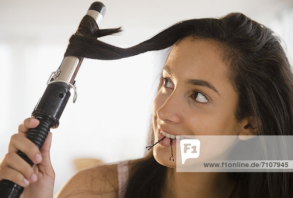 Hispanic teenager curing her hair