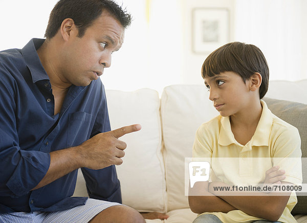 Hispanic father lecturing son