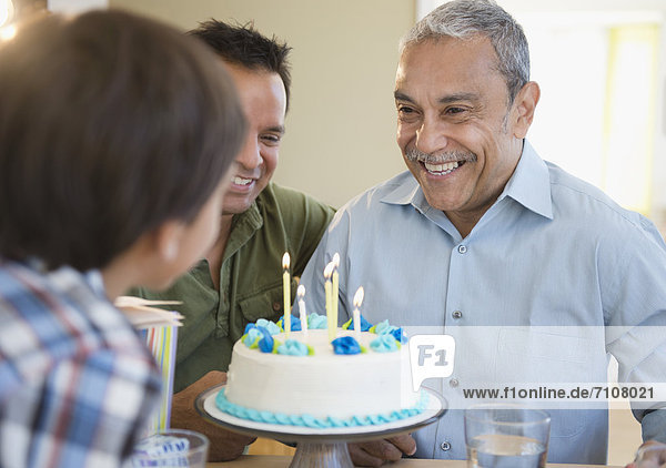 Hispanic grandfather  father and son celebrating birthday