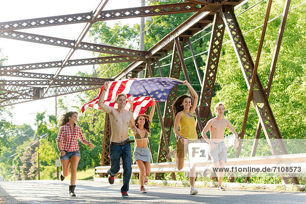 Gruppe von Freunden auf der Brücke mit amerikanischer Flagge