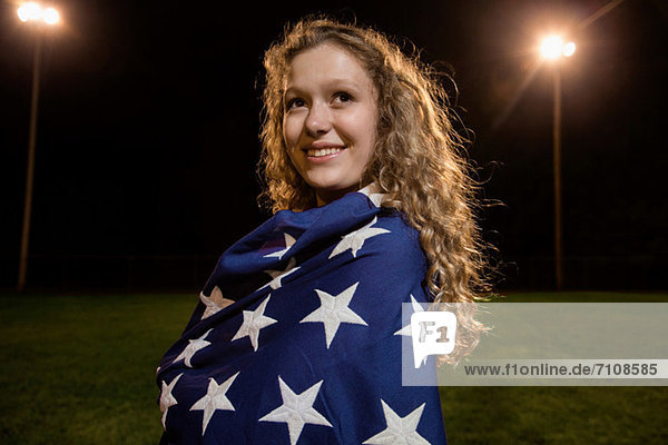 Mädchen in amerikanische Flagge gehüllt bei Nacht