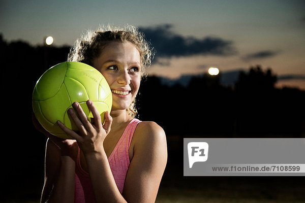 Mädchen mit Fußball bei Nacht