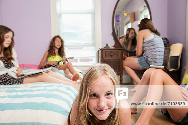 Mädchen schaut in die Kamera  Freunde im Hintergrund