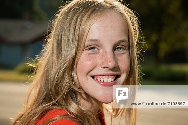 Close up portrait of blonde girl looking at camera smiling