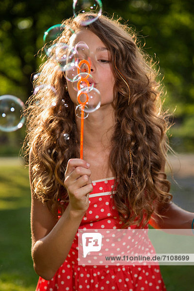 Mädchen bläst Blasen mit Blasenstab