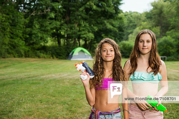 Porträt von zwei Mädchen mit Wasserpistolen