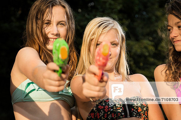 Mädchen zielen mit Wasserpistolen auf die Kamera