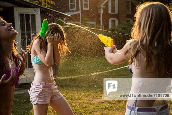 Mädchen im Wasserkampf mit Wasserpistolen