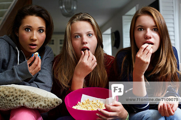 Teenager-Mädchen beim Horrorfilm mit Popcorn