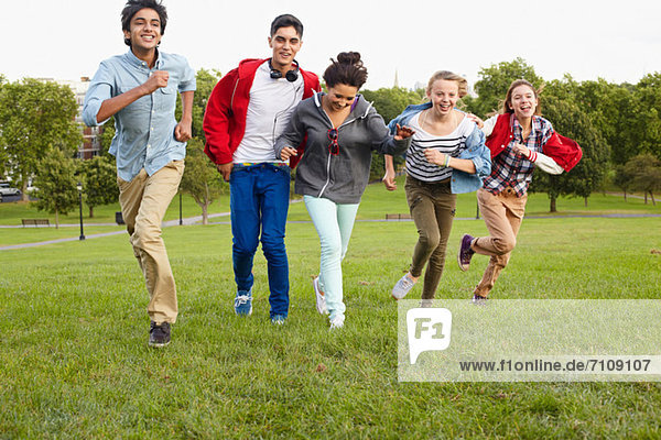 Teenagers running in a park