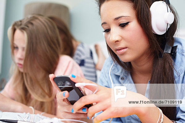 Teenage girl listening to music player