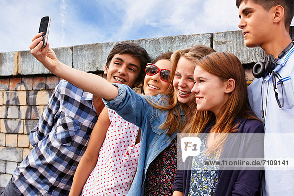 Teenage friends photographing themselves with smartphone
