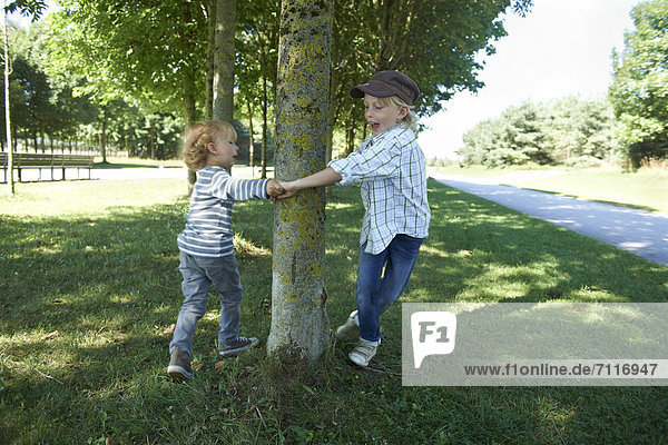Zwei Jungen tanzen um Baum