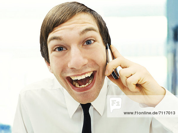 Smiling businessman with a happy face speaking on this mobile phone