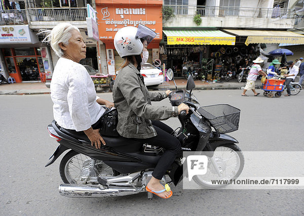 Two women on a motor scooter  Phnom Penh  Cambodia  Southeast Asia  Asia