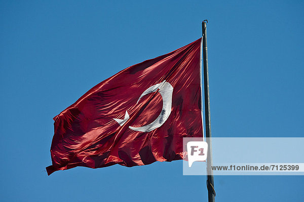 Truthuhn  blasen  bläst  blasend  Wind  Stange  Schiffsmast  Mast  Fahne  Reklameschild  Flattern  Nationalflagge  Fahnenmast  Türkei  türkisch  Wasserwelle  Welle