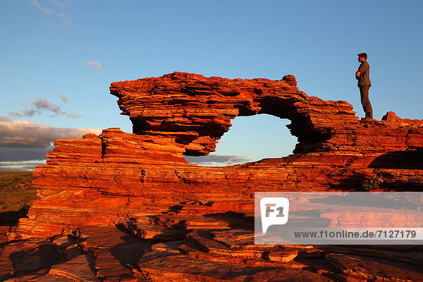 Sehenswürdigkeit Mann Stein Fenster Wolke Sonnenuntergang Steilküste Küste weiß Brücke Kurve Sand rot Ansicht Streifen Schlucht Australien Kalbarri Westküste Western Australia