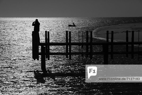 Fußgängerbrücke Mann Boot Meer hinaussehen Gegenlicht Australien Western Australia