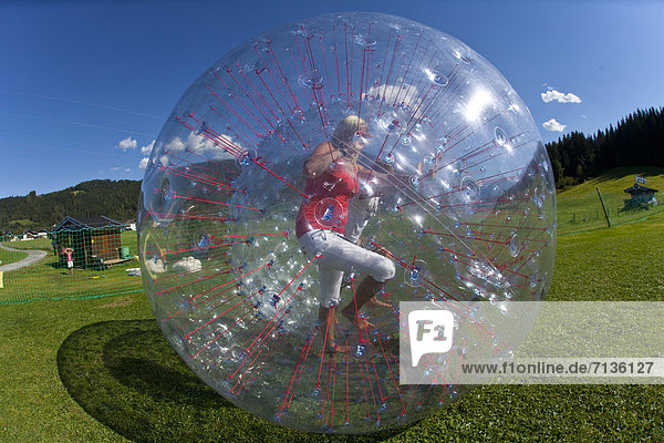 Austria  Europe  Flachau  teenager  Twens  Zorbing  ball  sphere  clear  air cushion  fun  meadow  couple  man  woman
