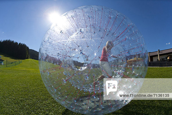 Austria  Europe  Flachau  teenager  Twens  Zorbing  ball  sphere  clear  air cushion  fun  meadow  woman