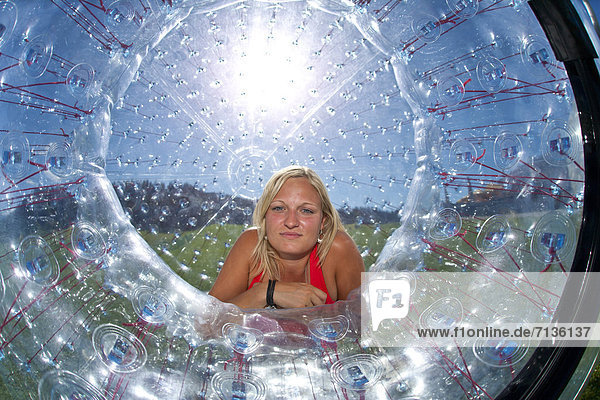 Austria  Europe  Flachau  teenager  Twens  Zorbing  ball  sphere  clear  air cushion  fun  meadow  woman
