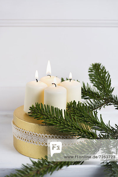 Adventskranz mit weißen Kerzen und Tannenzweig
