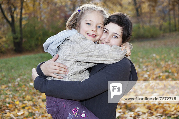 Teenage girl  14 years  holding girl  6 years  in her arms
