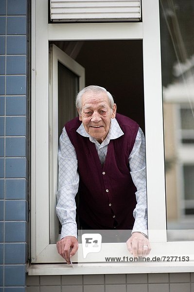 Mensch Menschen Fenster Wohnhaus Zimmer Straße Senior Senioren Seitenansicht Niederlande Bevölkerungsgruppe Wohnzimmer hinauslehnen Rotterdam