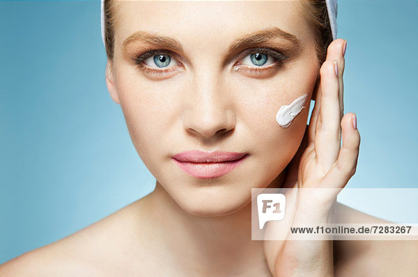 Woman applying moisturiser