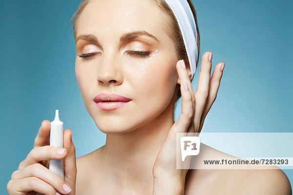 Woman applying eye cream