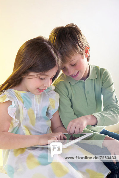 Mädchen und Junge mit digitalem Tablett