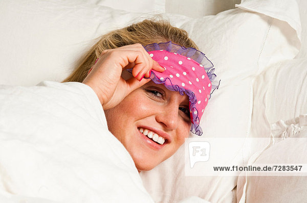 Frau mit Augenmaske im Bett