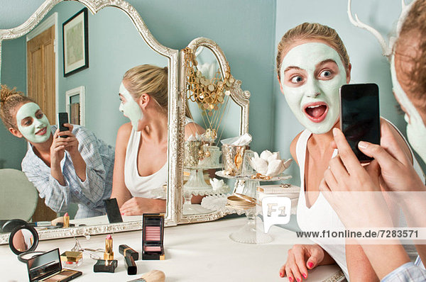 Frau mit Gesichtsmaske  die von einem Freund fotografiert wird.