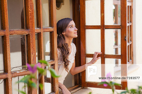 Junge Frau schaut aus dem Fenster